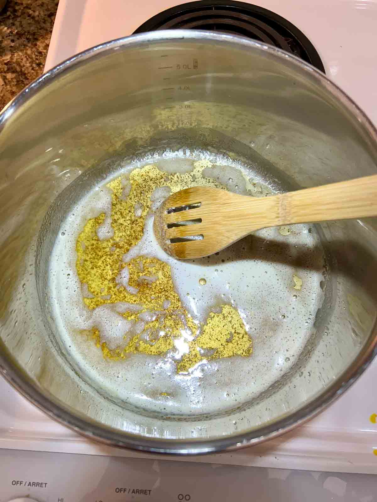 butter being browned in pot. small brown specks are visible which indicate it is done.