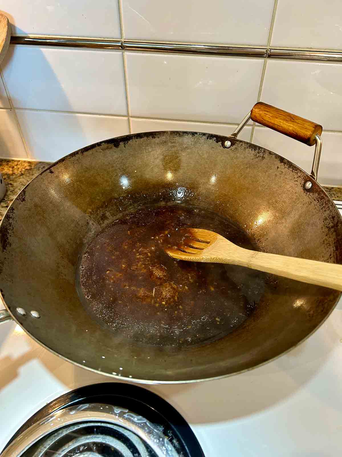 sauce being thickened in wok.