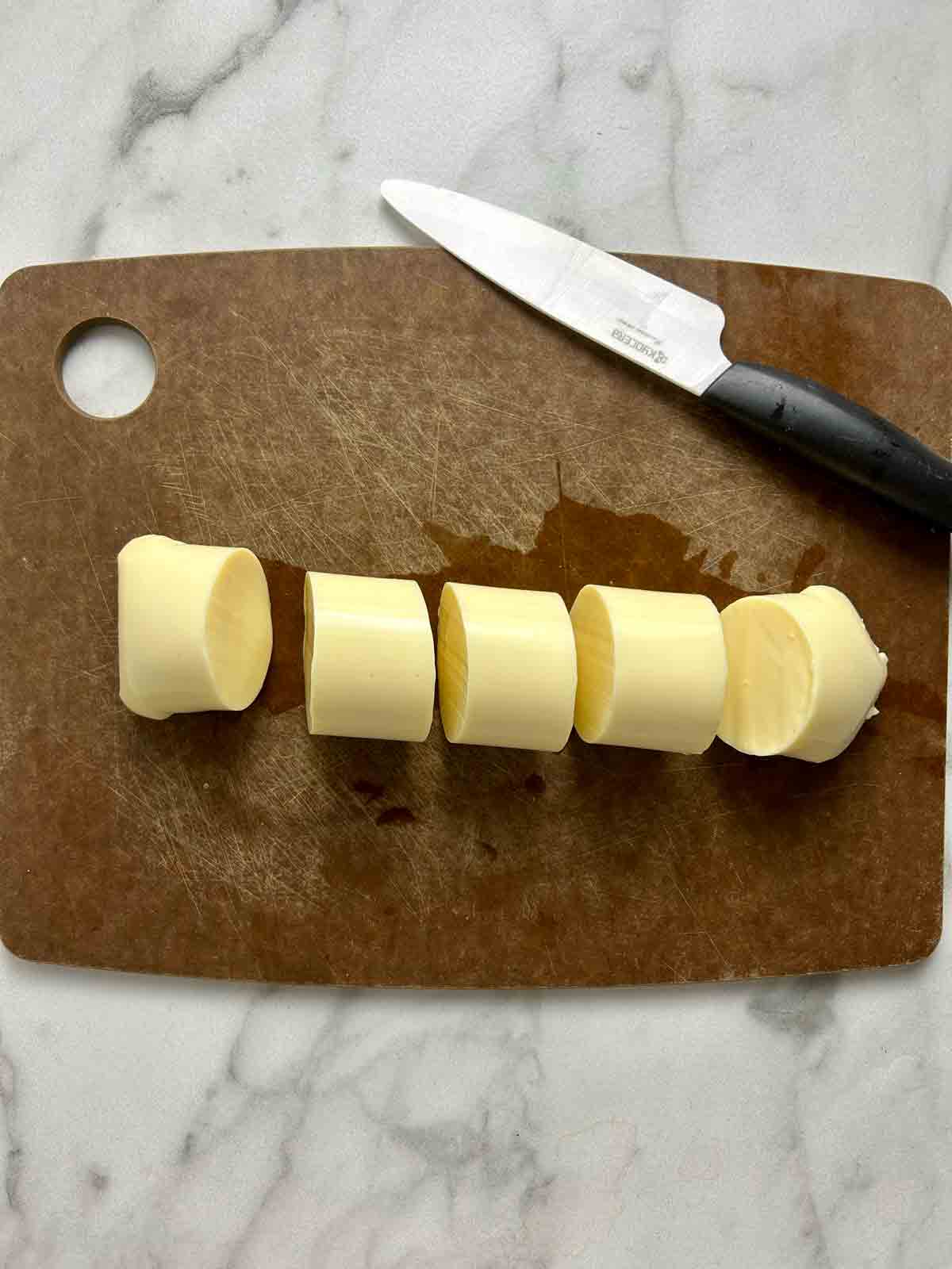 egg tofu cut into 5 slices on cutting board.