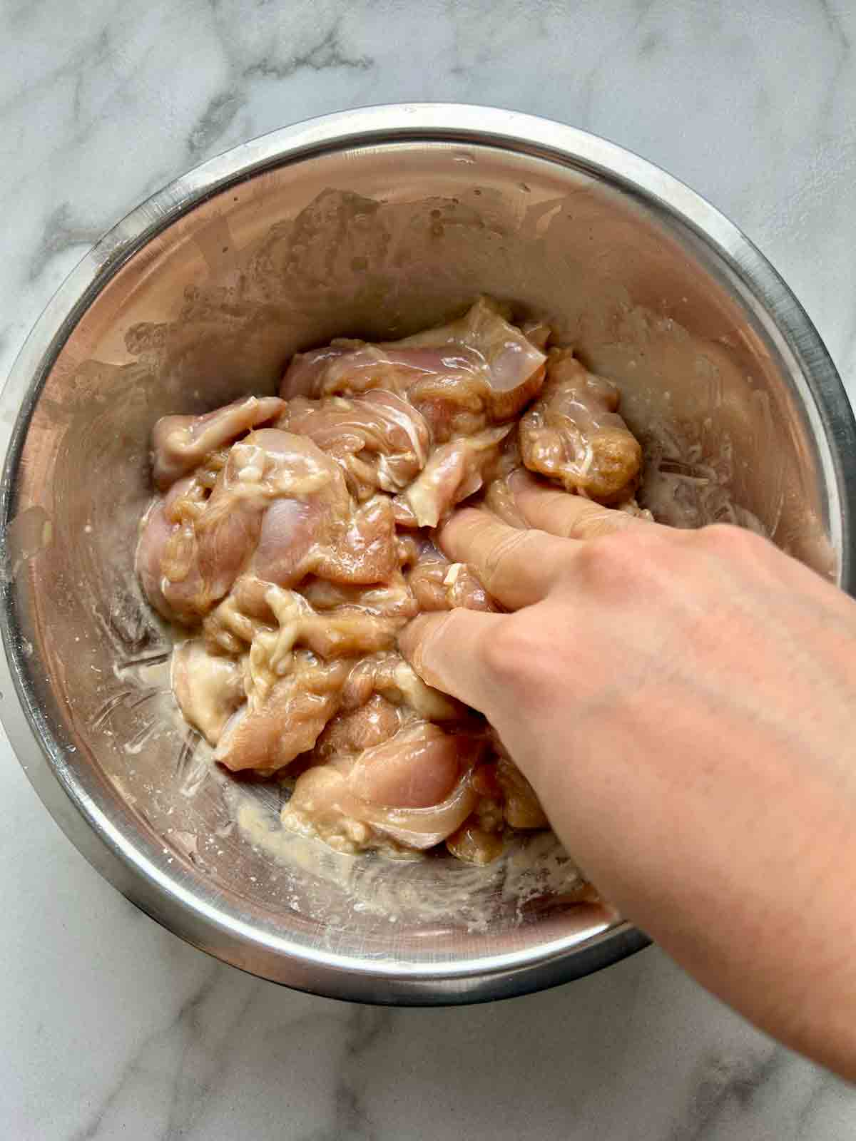 hand mixing marinade ingredients in bowl.