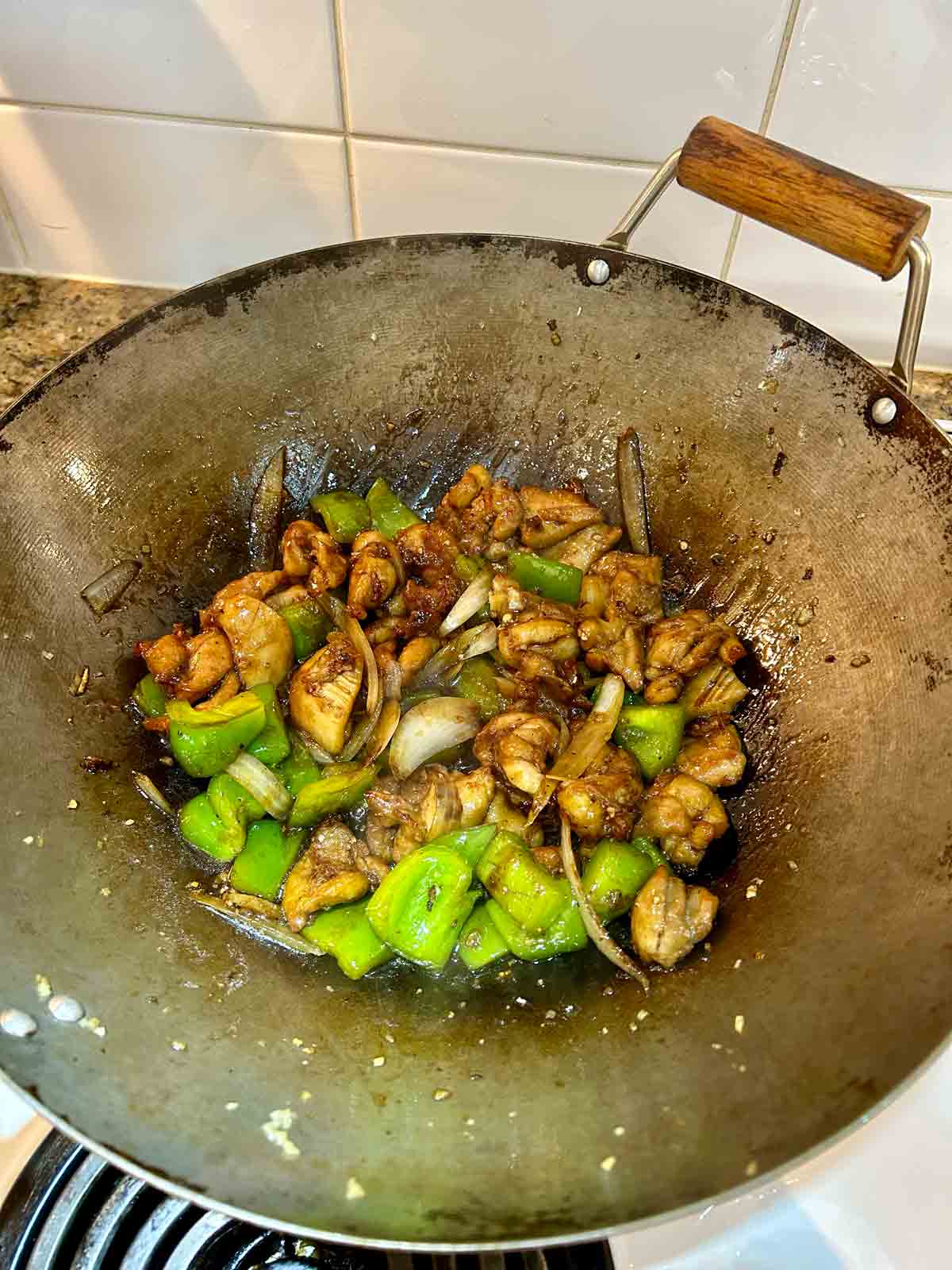 sauce added and mixed with stir-fry in wok.