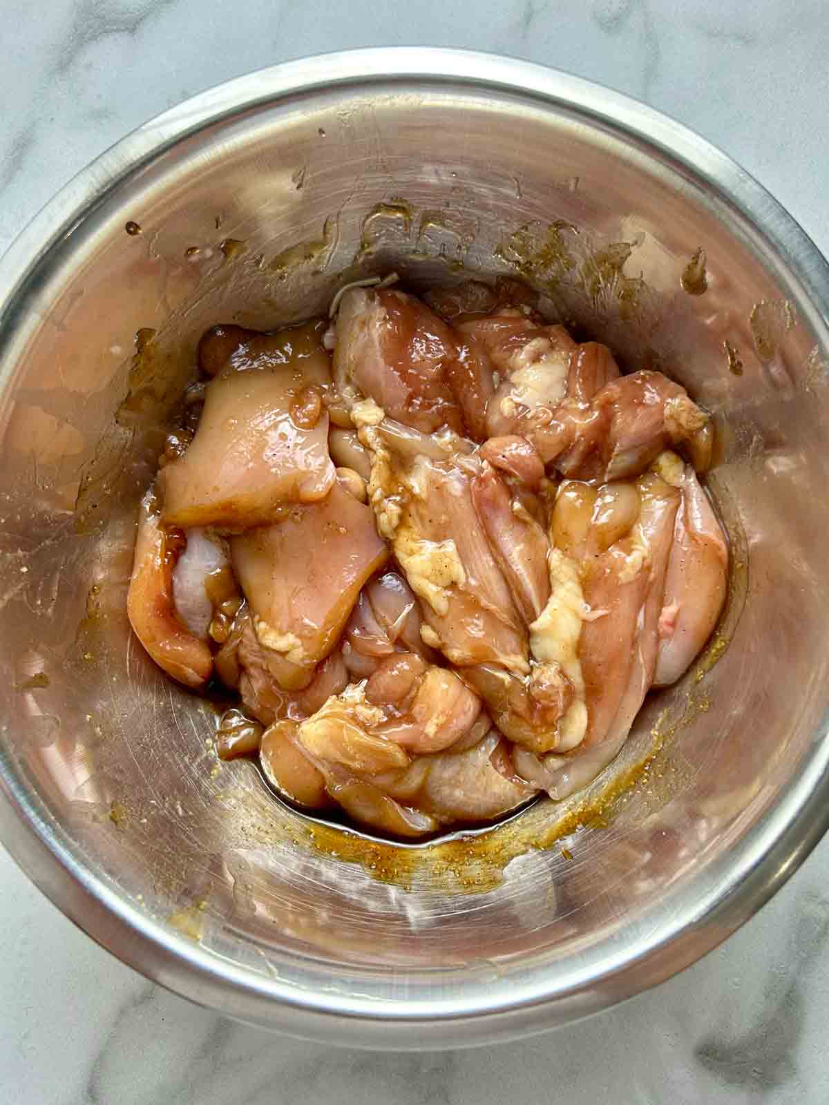 chicken pieces being marinated in sauce.