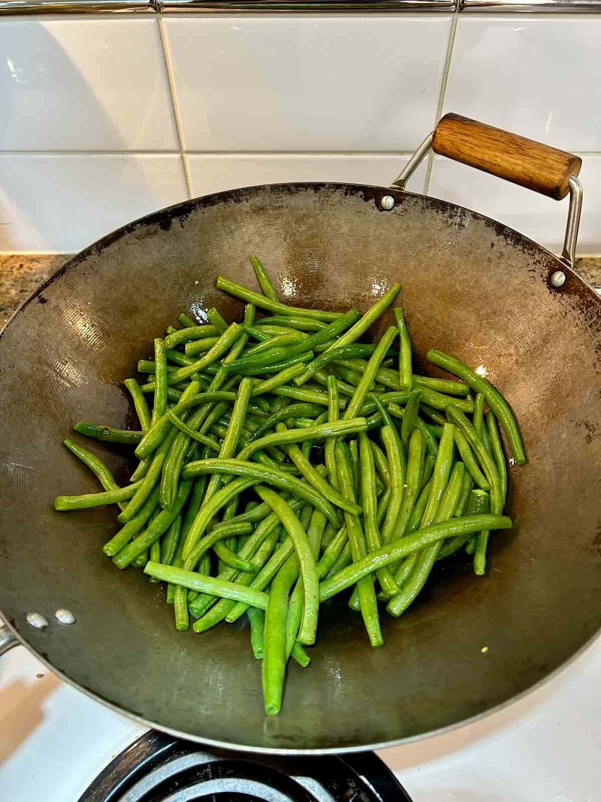 green beans added to wok.