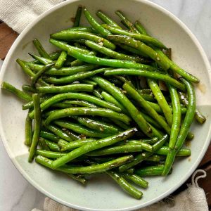 overhead shot of cooked green beans on a plate.