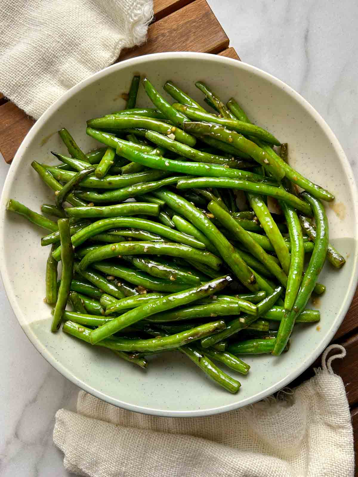 overhead shot of cooked green beans on a plate.