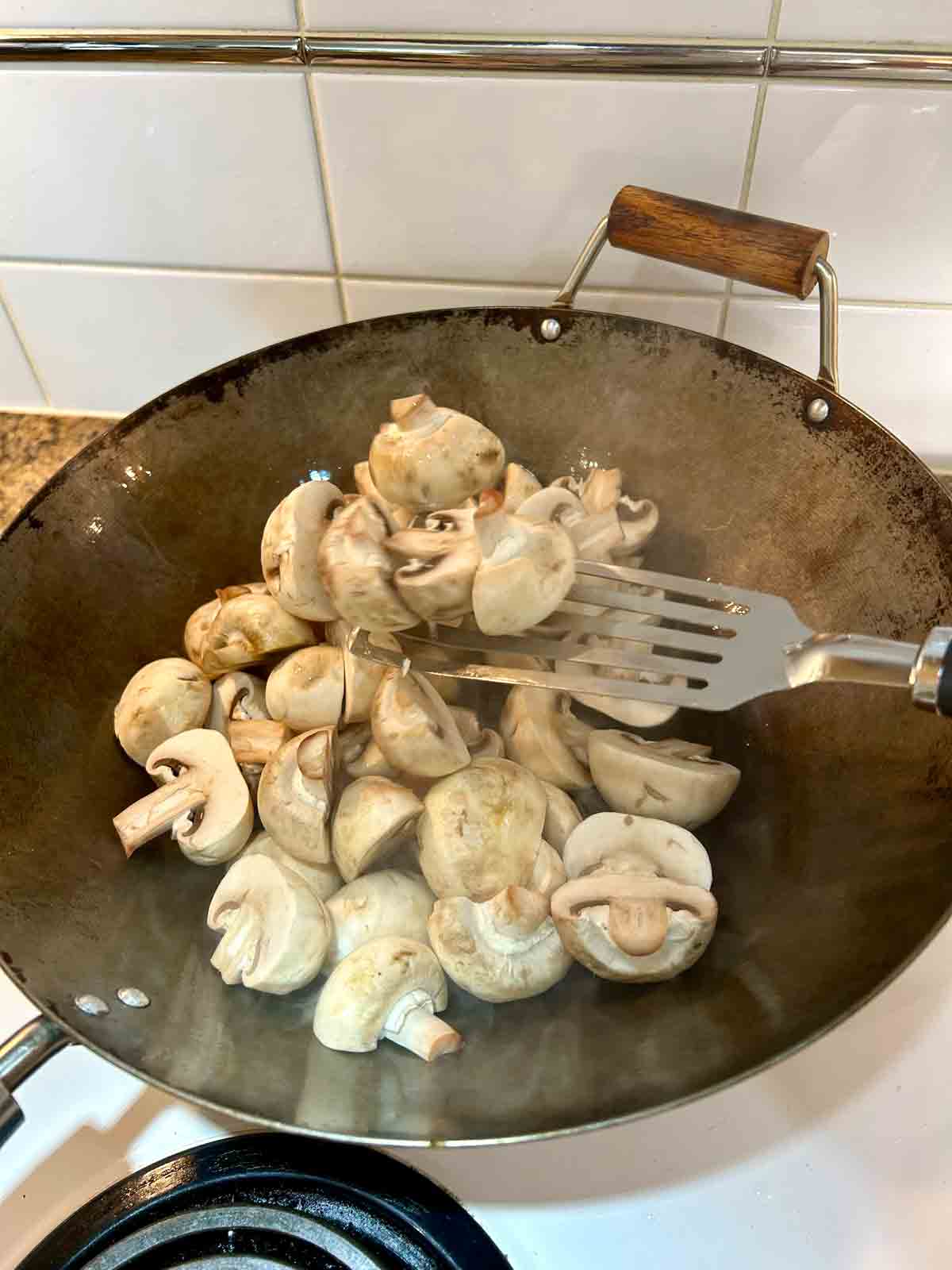 tossing mushrooms in wok.