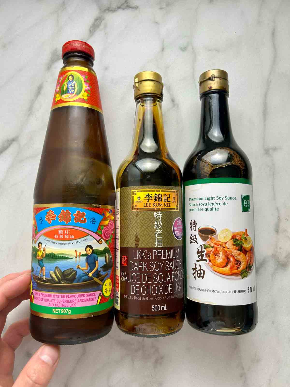 bottles of oyster sauce, dark soy sauce, and regular soy sauce.