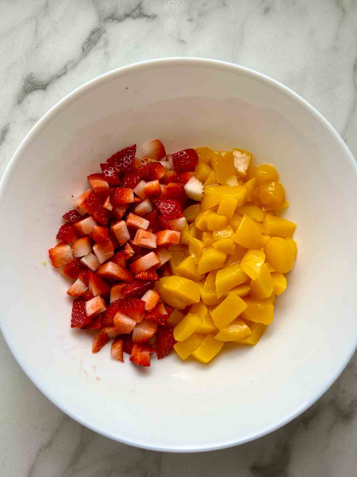 bowl of chopped strawberries and chopped peaches.