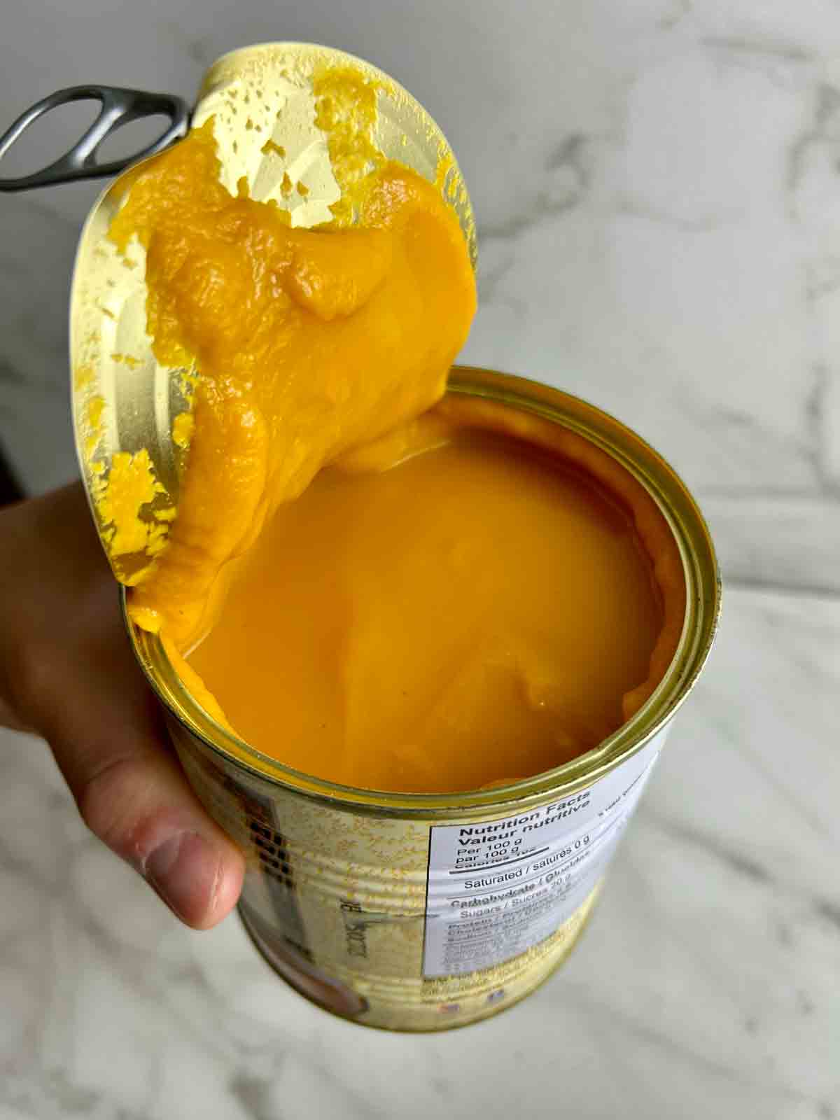 showing inside of opened can of mango pulp.