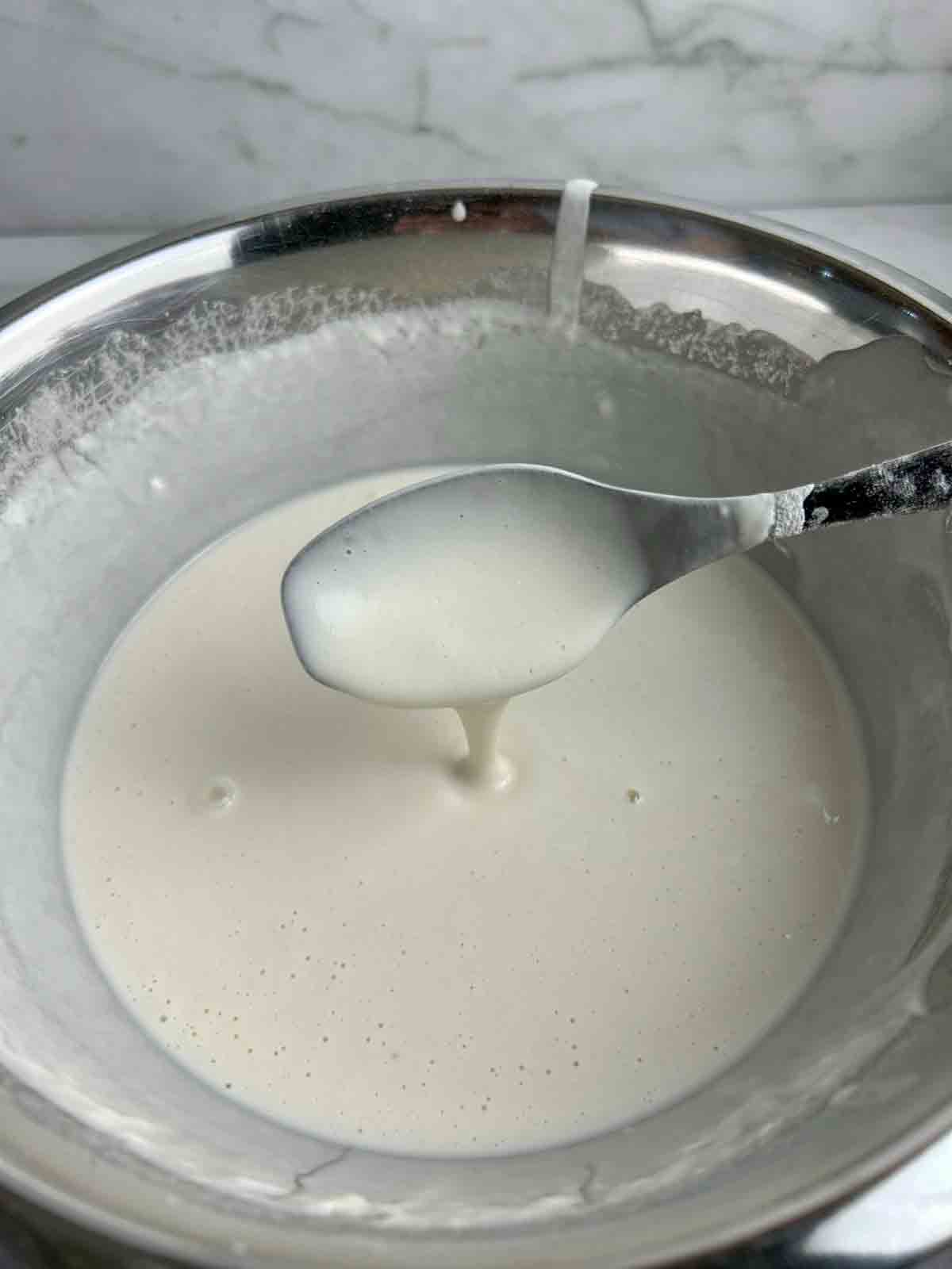 spoon lifting batter from bowl.