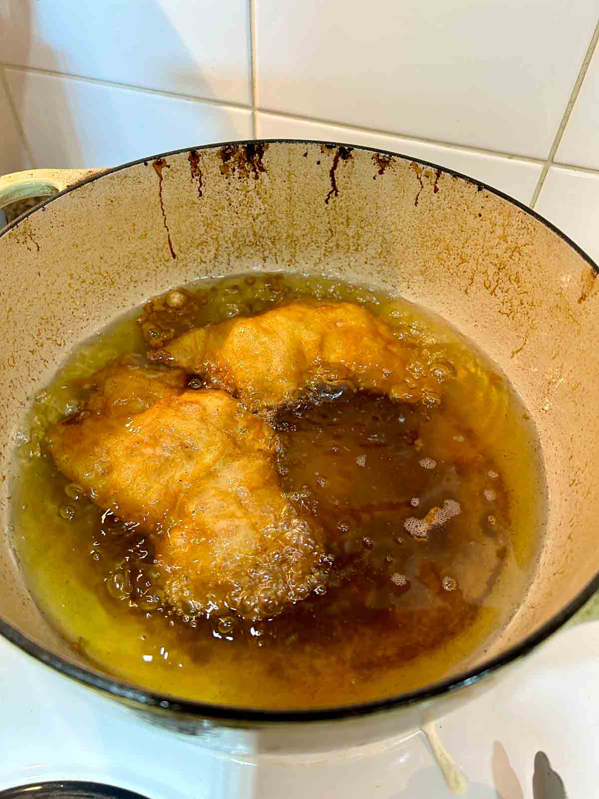 chicken pieces being fried in hot oil.