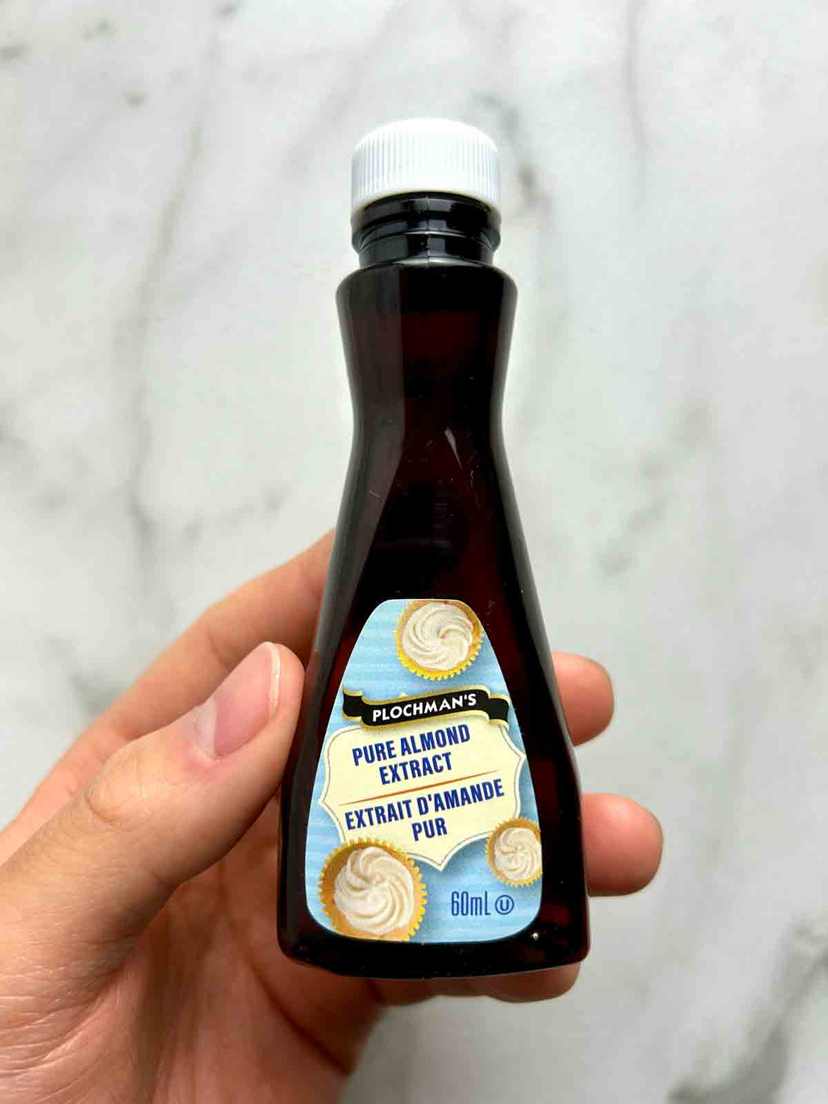 hand holding bottle of almond extract.