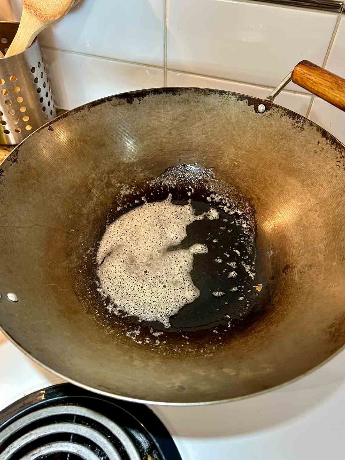 butter being melted in wok until no longer foaming.