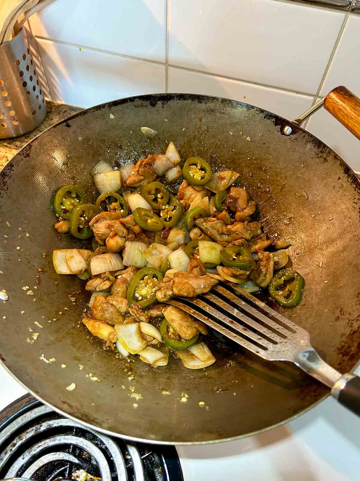 chicken and sauces being tossed with rest of stir-fry.