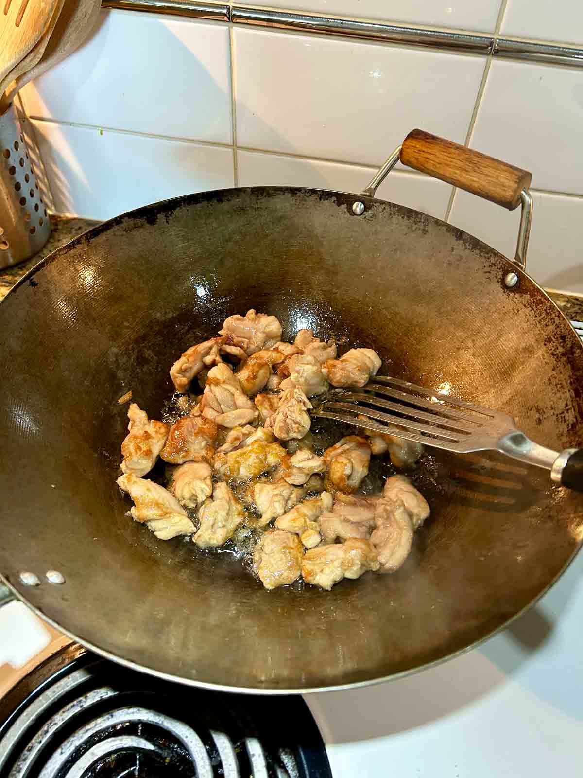 chicken being cooked in wok.