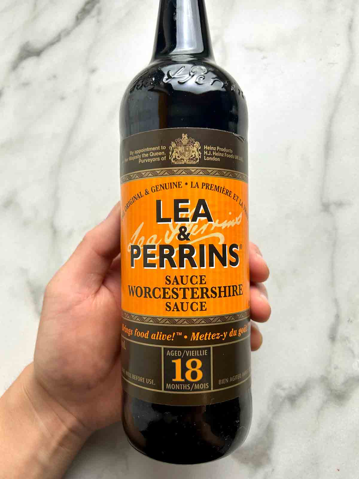 hand holding bottle of Worcestershire sauce.