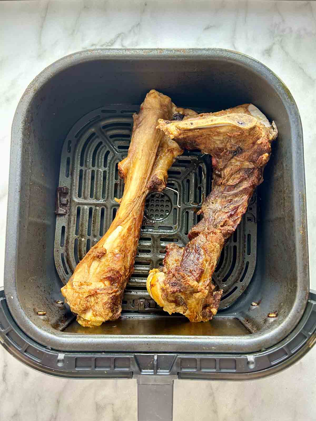 roasted lamb bone in air fryer basket.