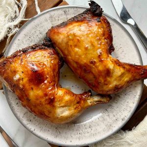 two roasted chicken legs on plate.