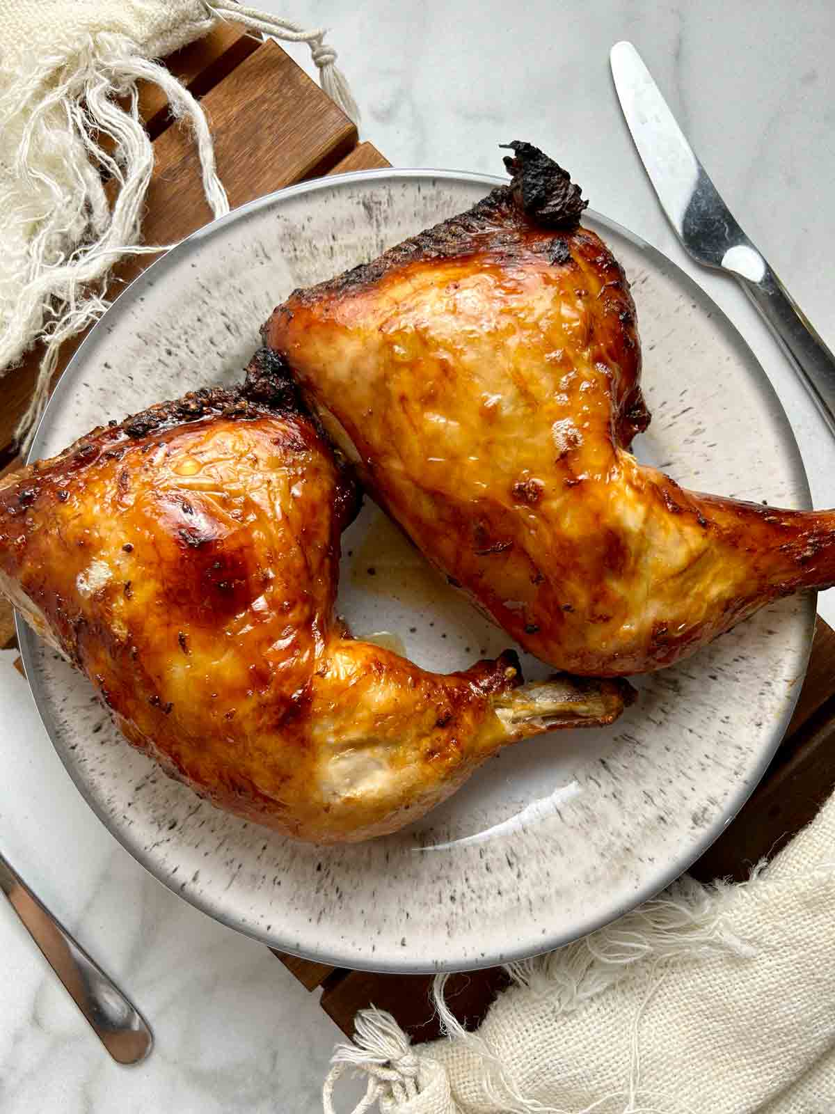 two roasted chicken legs on plate.