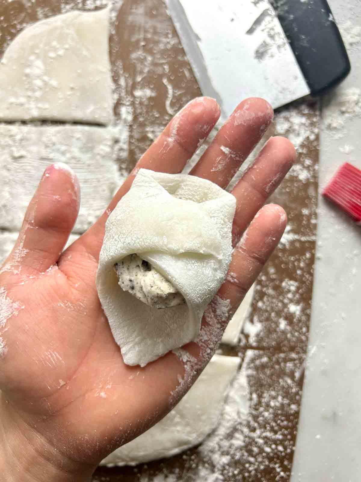 ice cream being wrapped with mochi on hand.