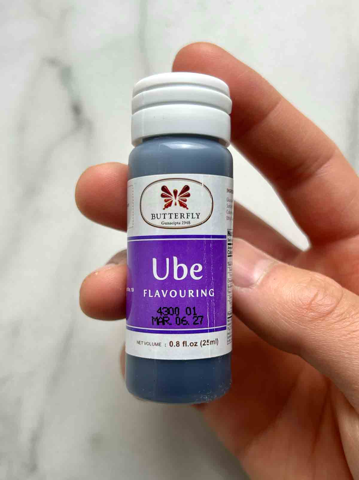 hand holding container of ube extract.