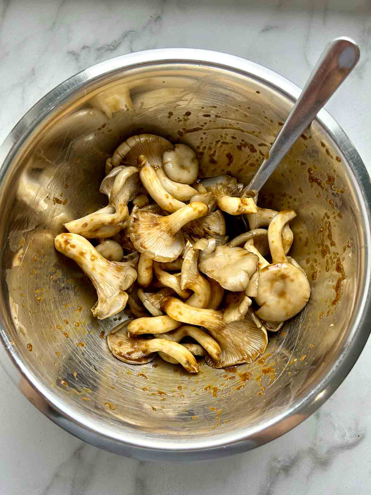 oyster mushrooms mixed with seasonings in bowl.