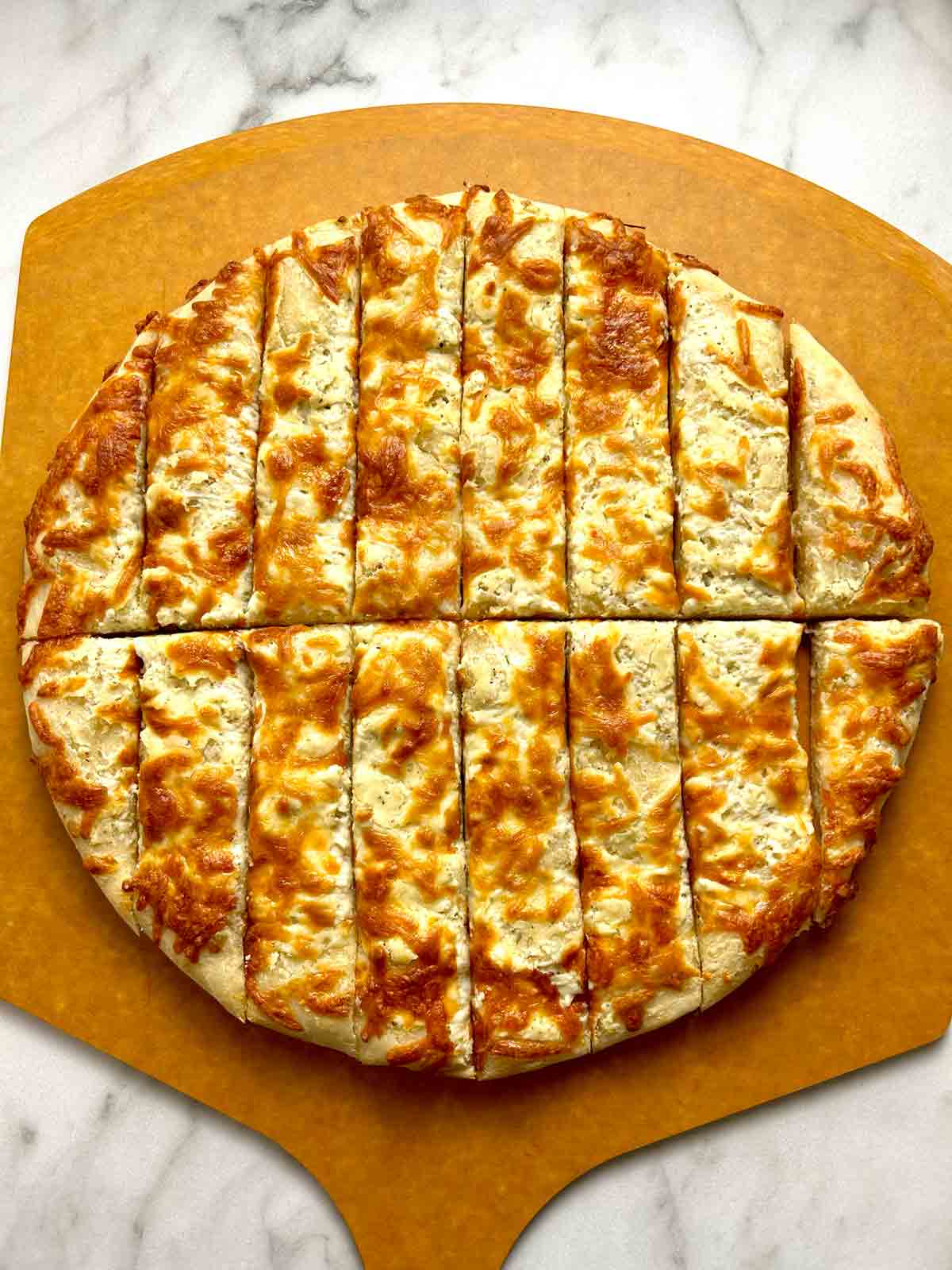 cream cheese pizza cut into sticks on pizza peel.