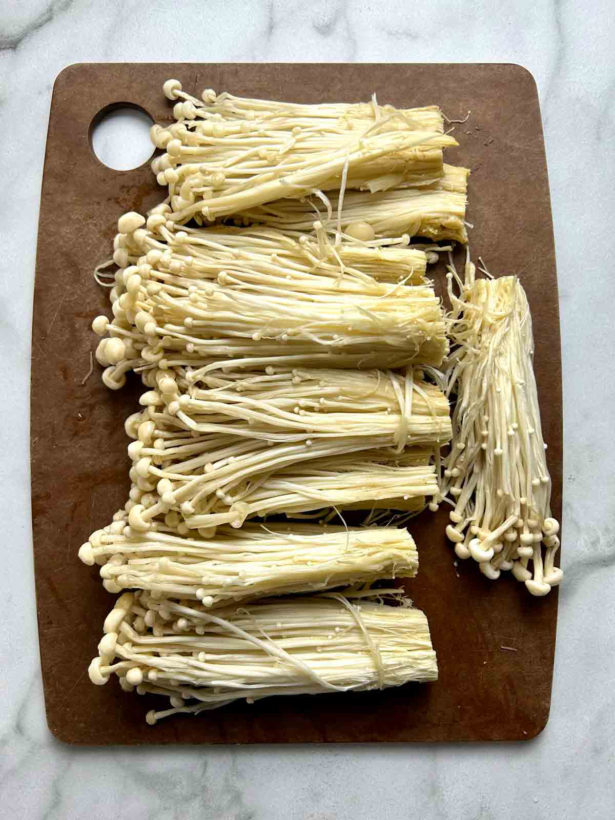 enoki mushrooms cut into small bundles.