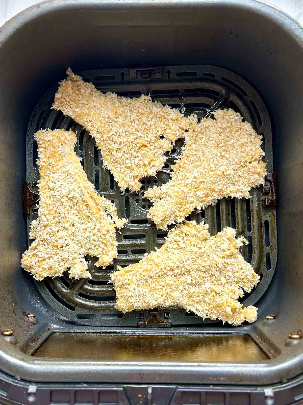 breaded enoki mushrooms in air-fryer basket.