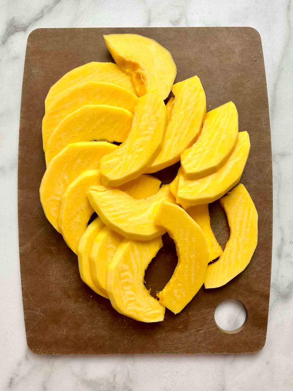 thin slices of Kabocha pumpkin on cutting board.