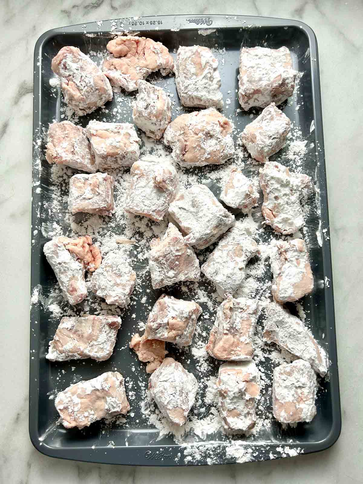 spare ribs being coated in starch mixture.