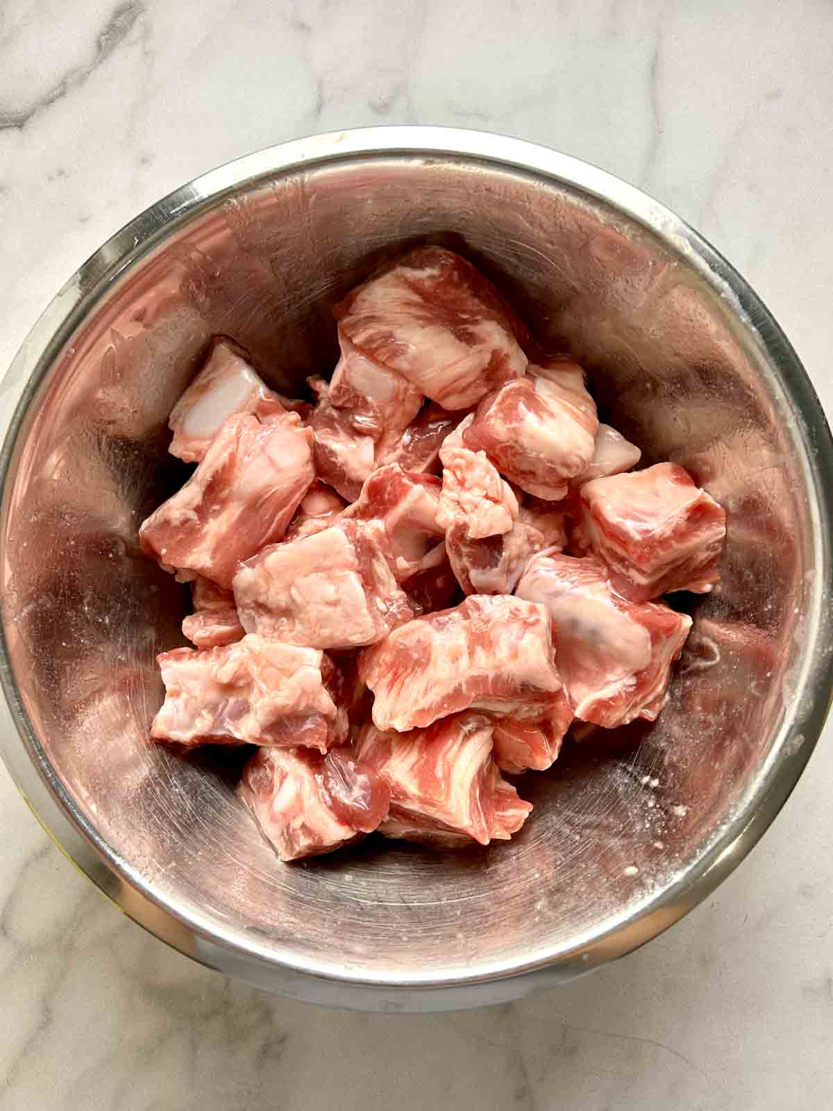 spare ribs being marinated in bowl.