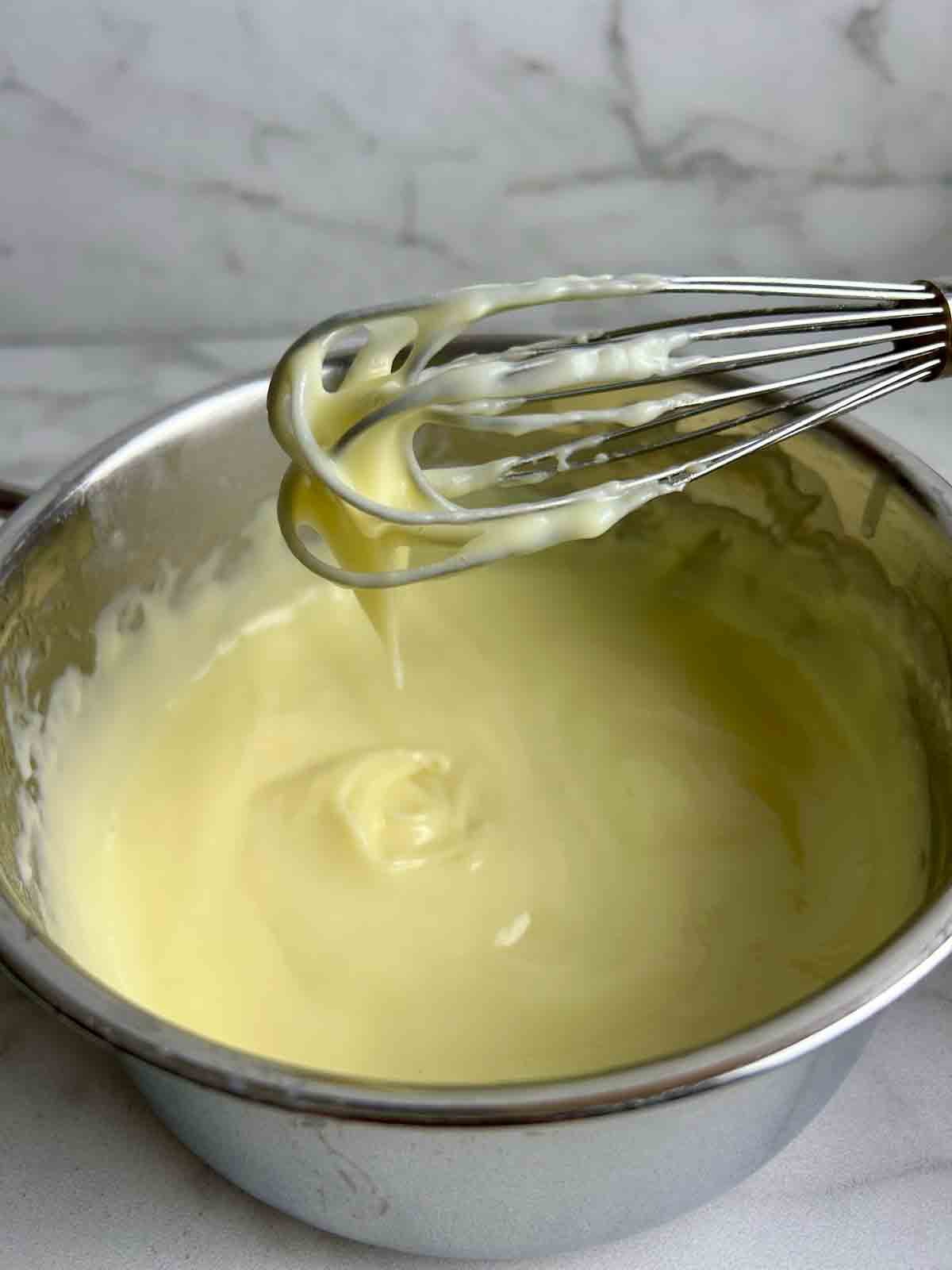 whisk lifting custard out of bowl.