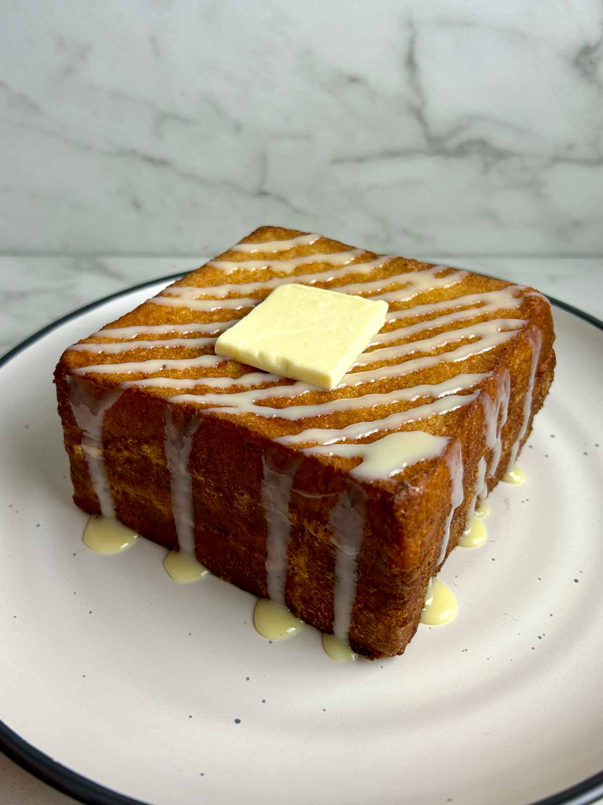 plate of Hong Kong French toast drizzled with condensed milk and a slab of butter,