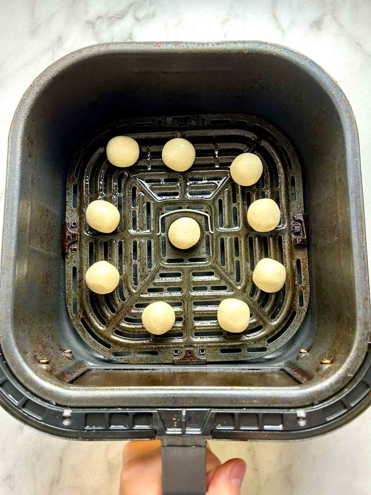 dough balls placed in air-fryer basket.