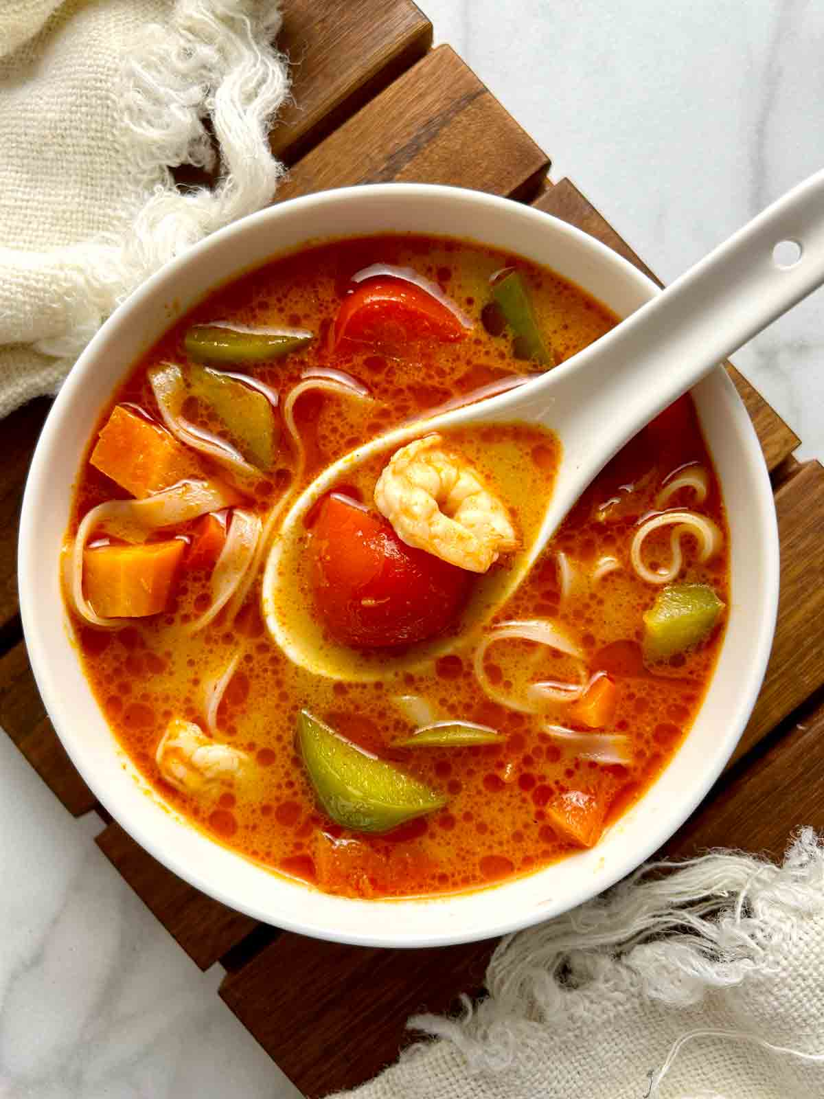 overhead of tom yum paste soup in bowl.