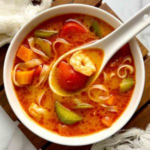 overhead of tom yum paste soup in bowl.