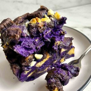 slice of ube bread pudding with a fork cutting into it