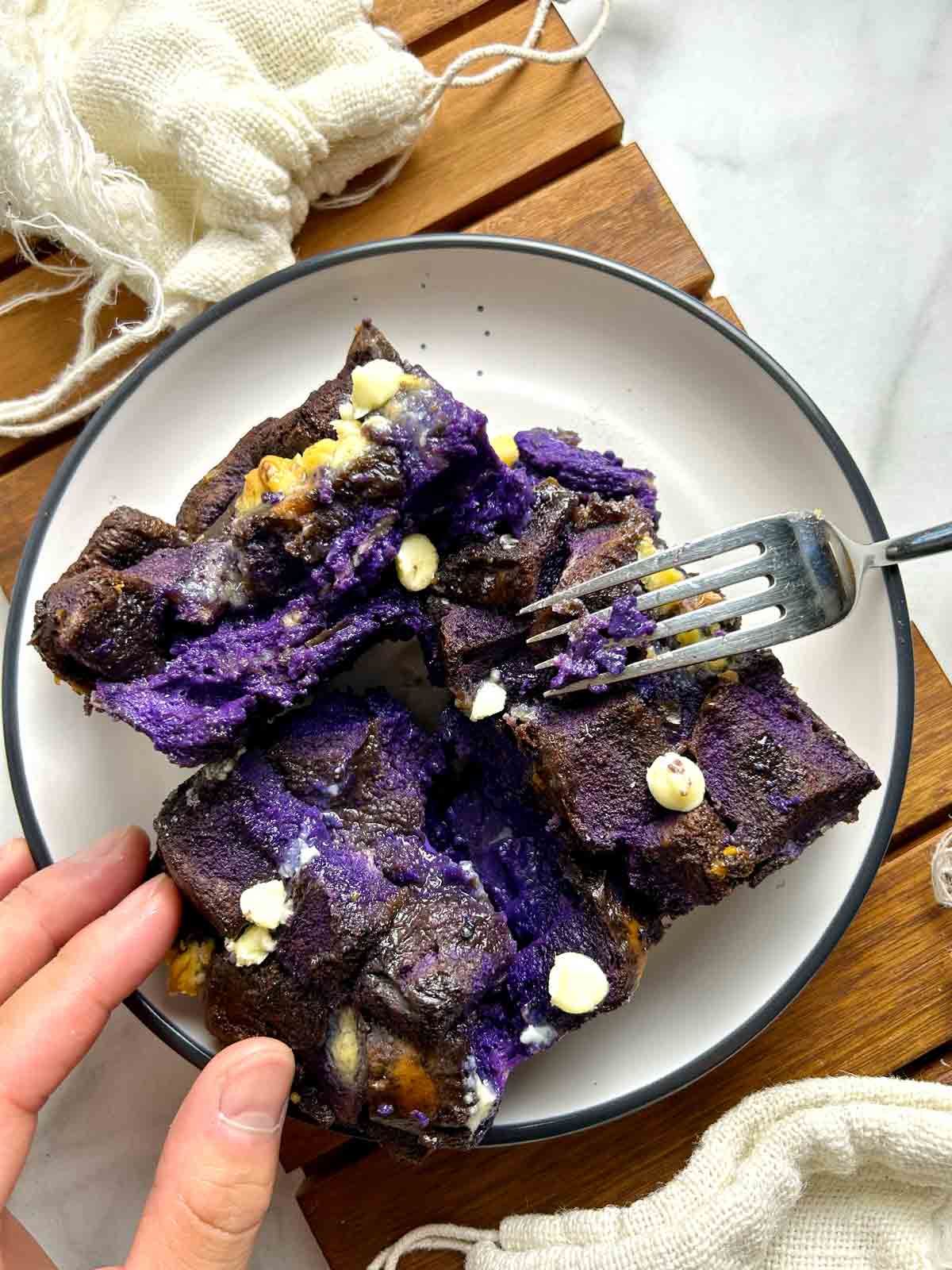 fork cutting into slice of ube bread pudding.