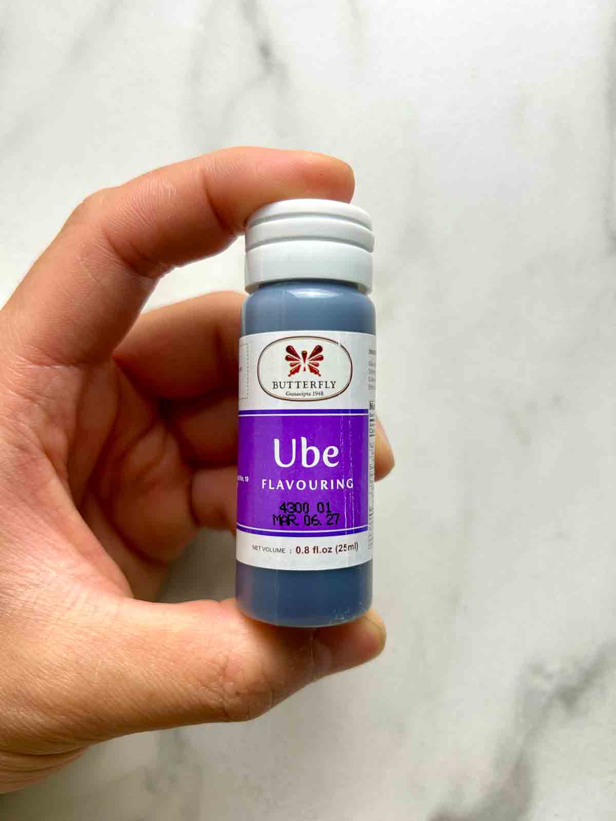 hand holding container of ube extract.