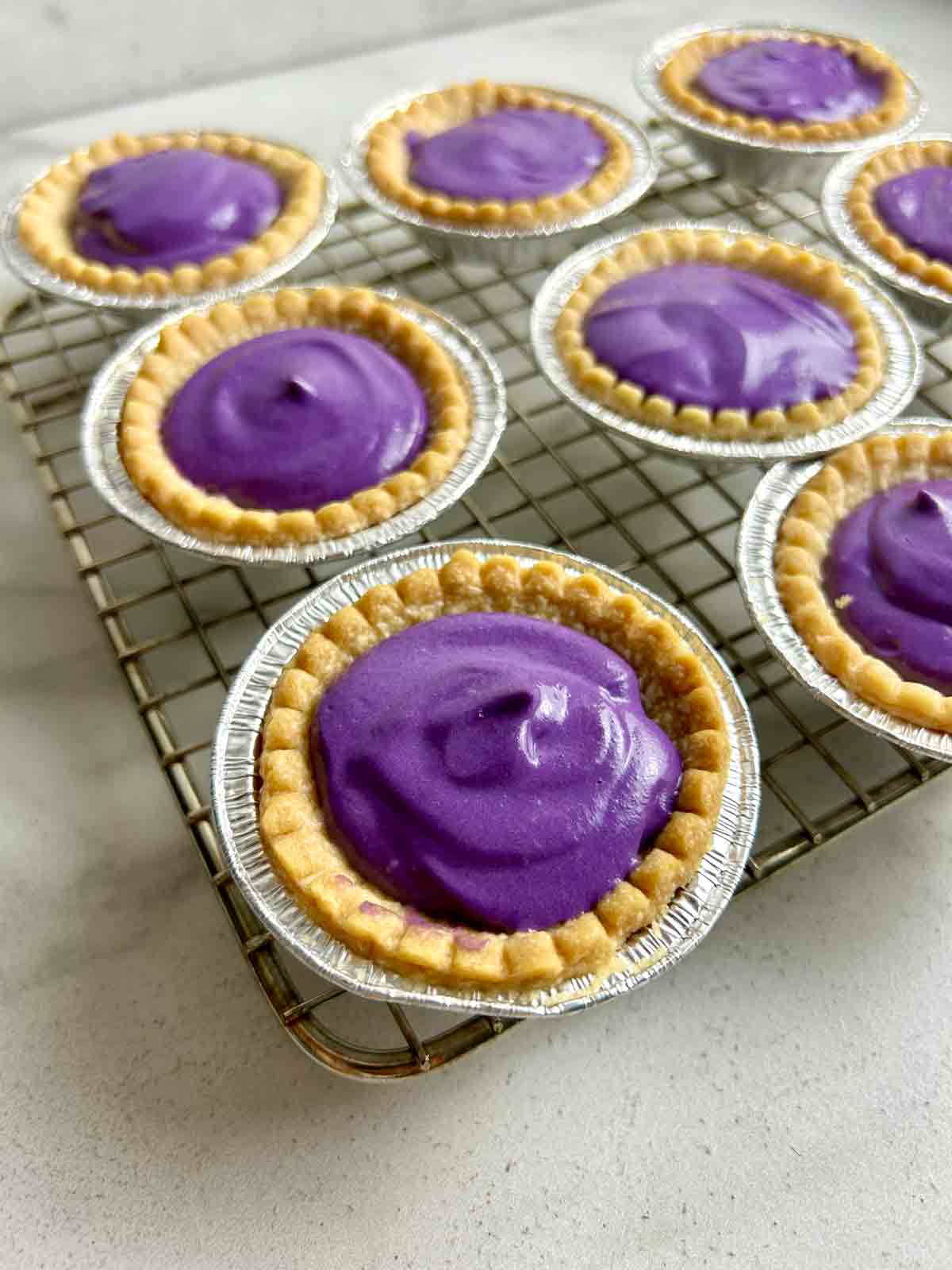 ube tarts on wire rack.