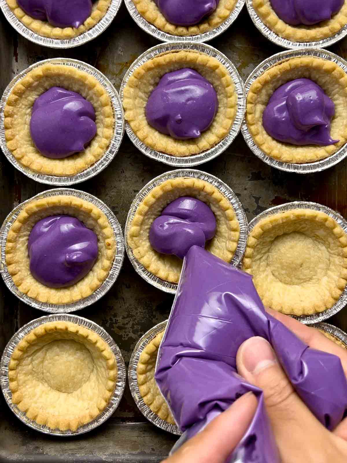 filling being piped into tart shells.