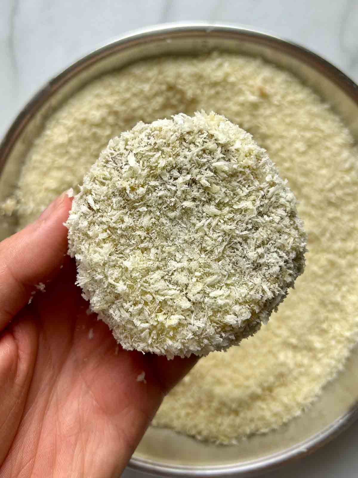 croquette being coated in breadcrumbs.