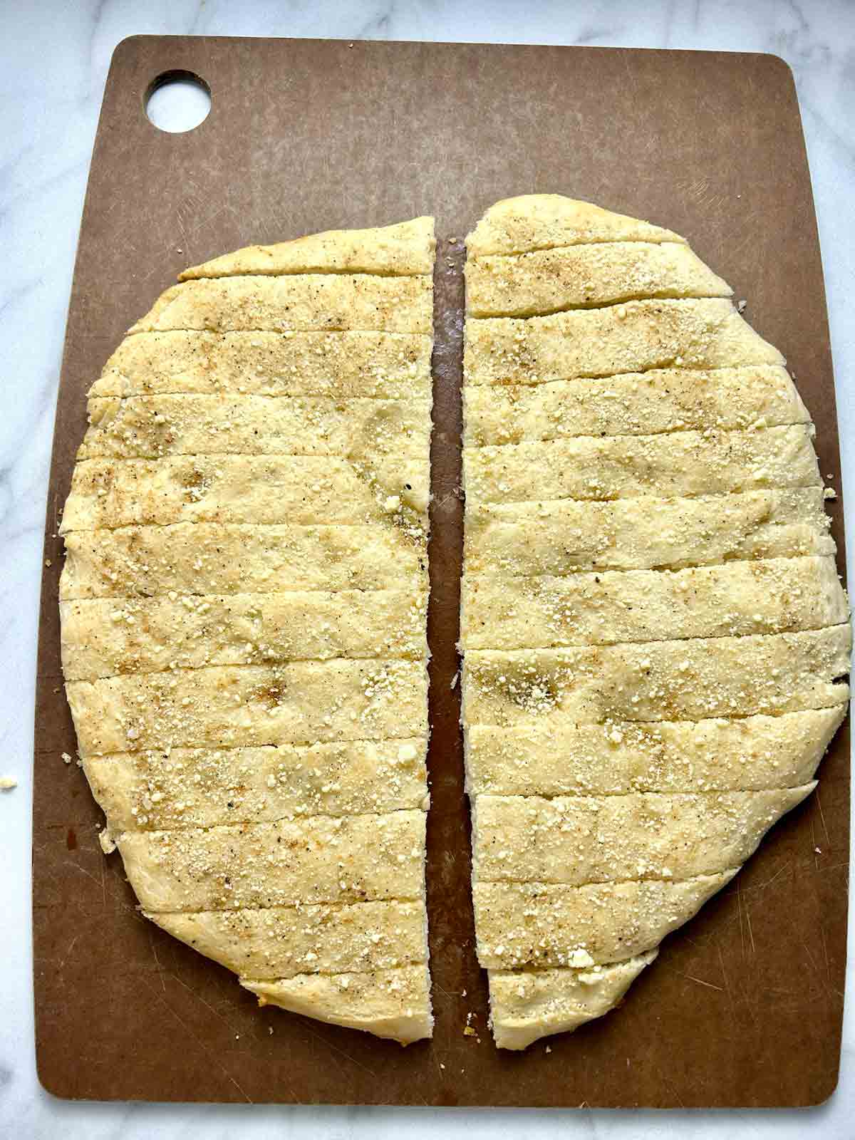 Bisquick breadsticks cut into sticks on cutting board.