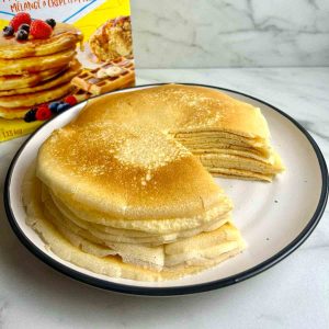 stack of crepes on a plate with a portion cut out, showing the cross-section.