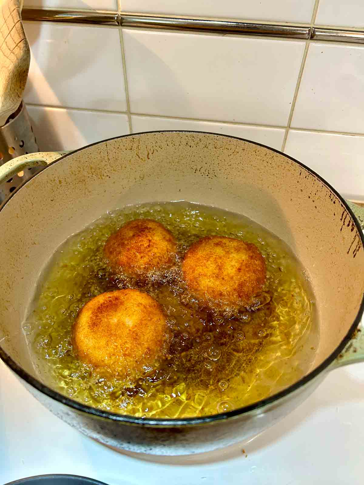 croquettes being deep-fried in oil.