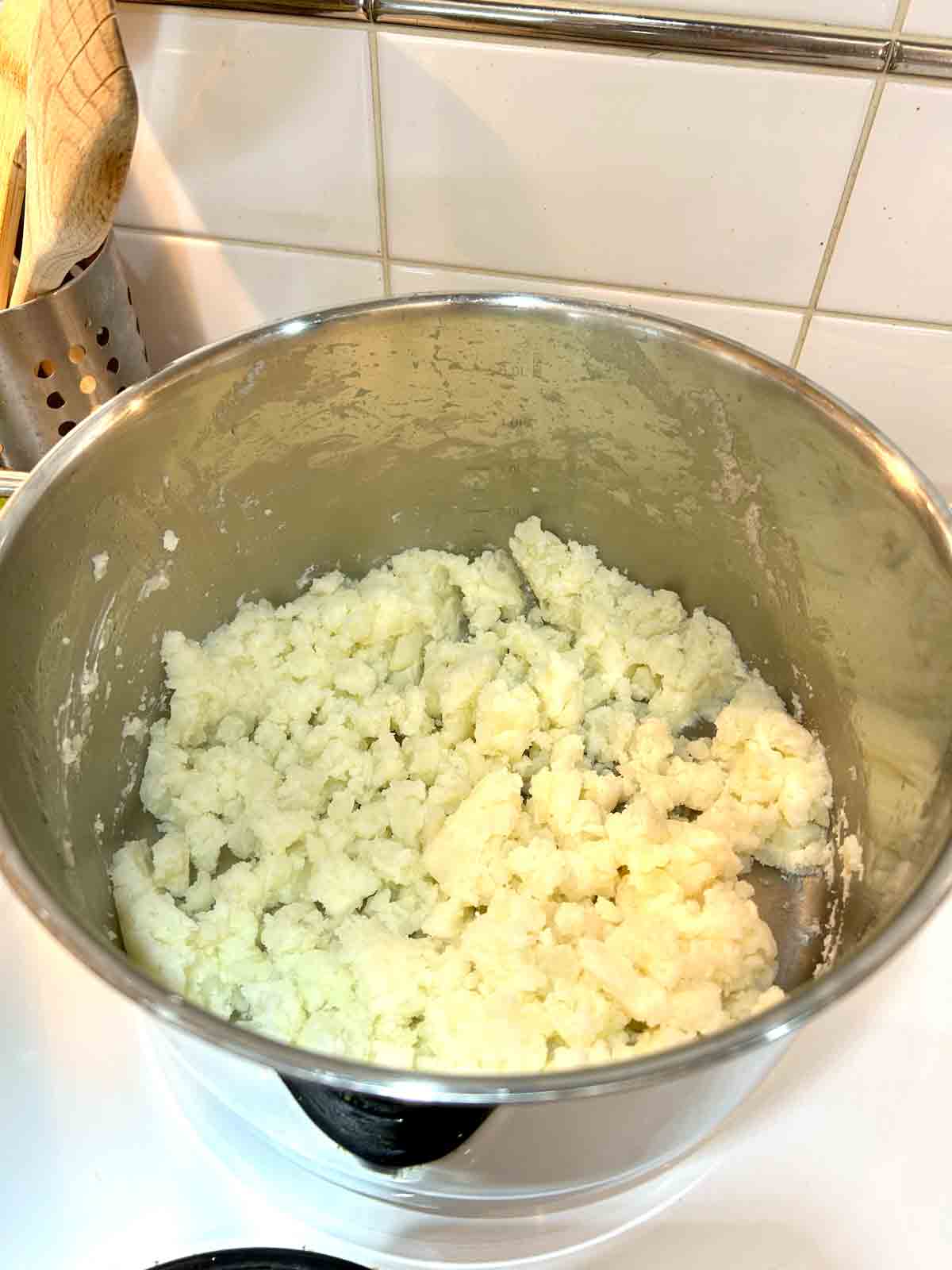 potatoes being mashed in pot.