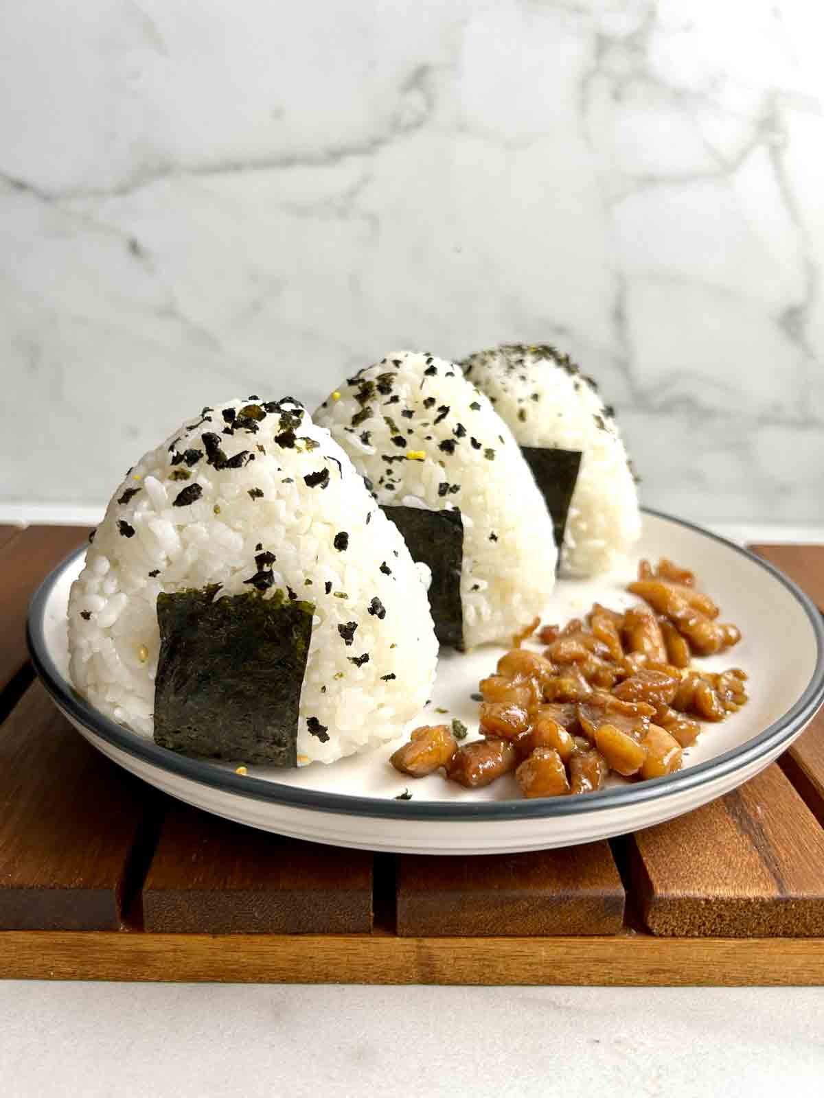 three chicken onigiri on plate with chicken filling.