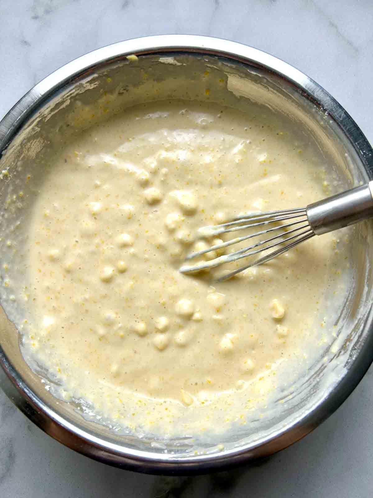 waffle batter in bowl with lumps of corn.