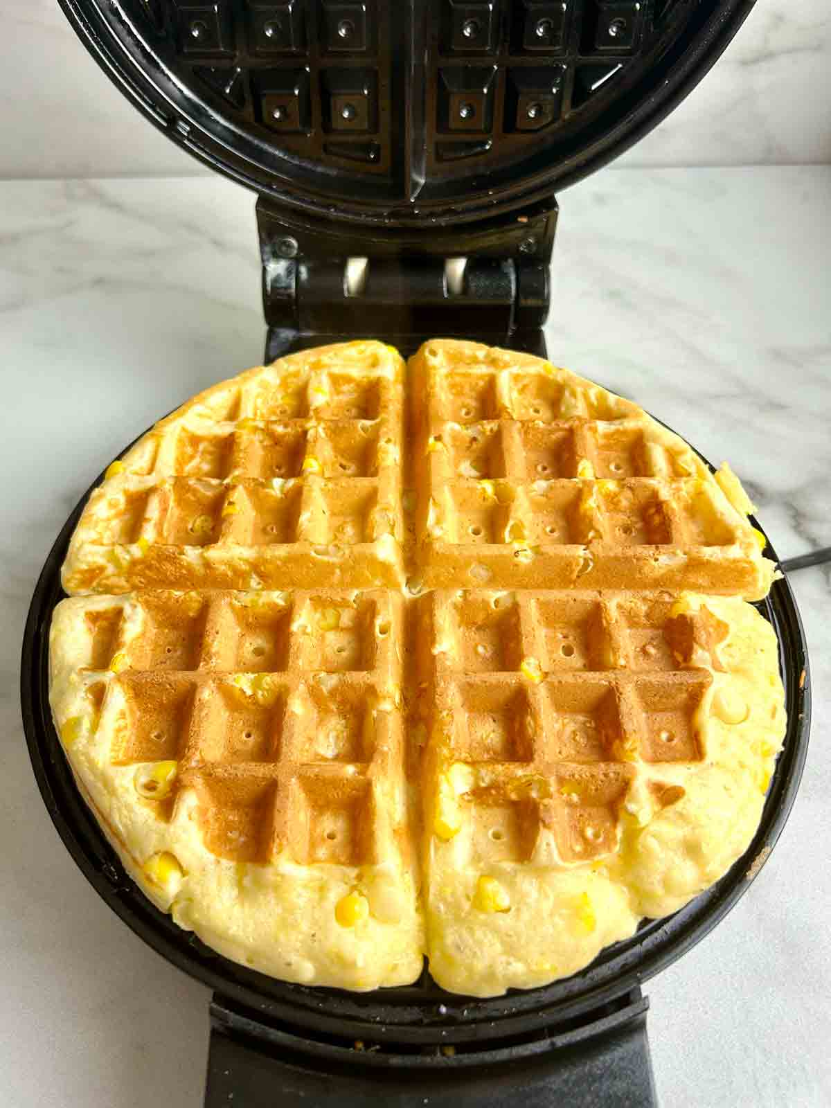 cooked waffle in waffle iron.